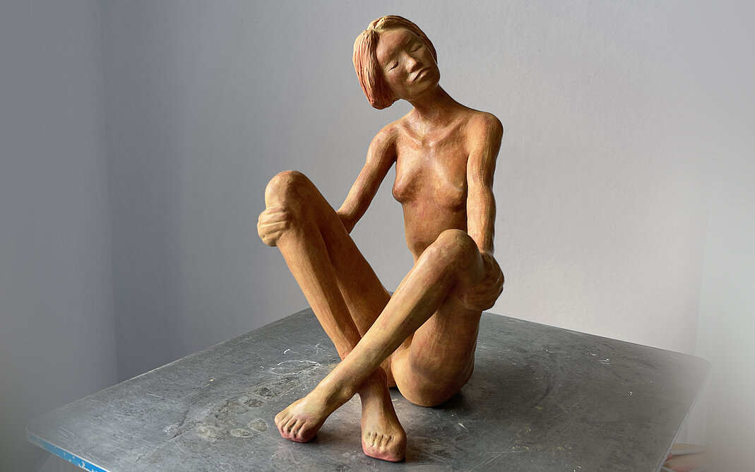 orange-rote Skulptur weiblich